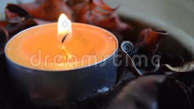 橘色的蜡烛与波普尔里的火焰在风中挥动在一个木碗里。
